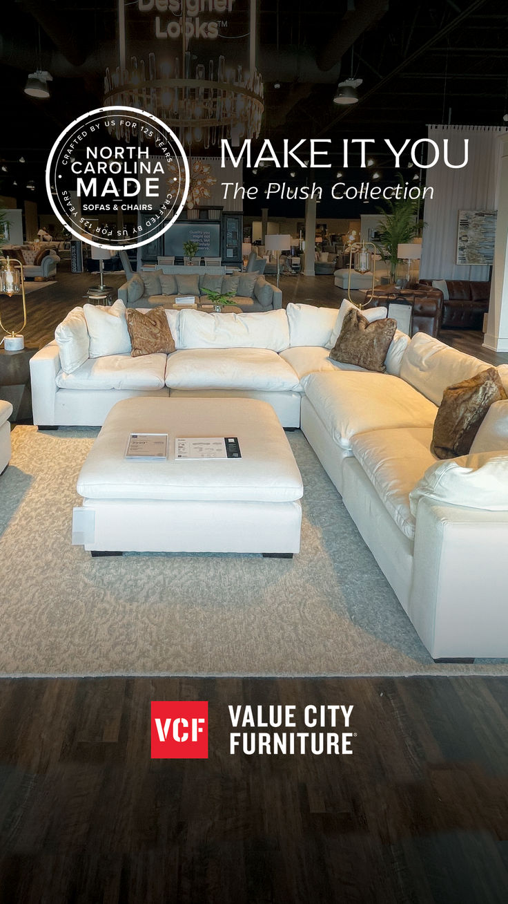 a living room with white couches and pillows on the floor in front of a sign that says make it you