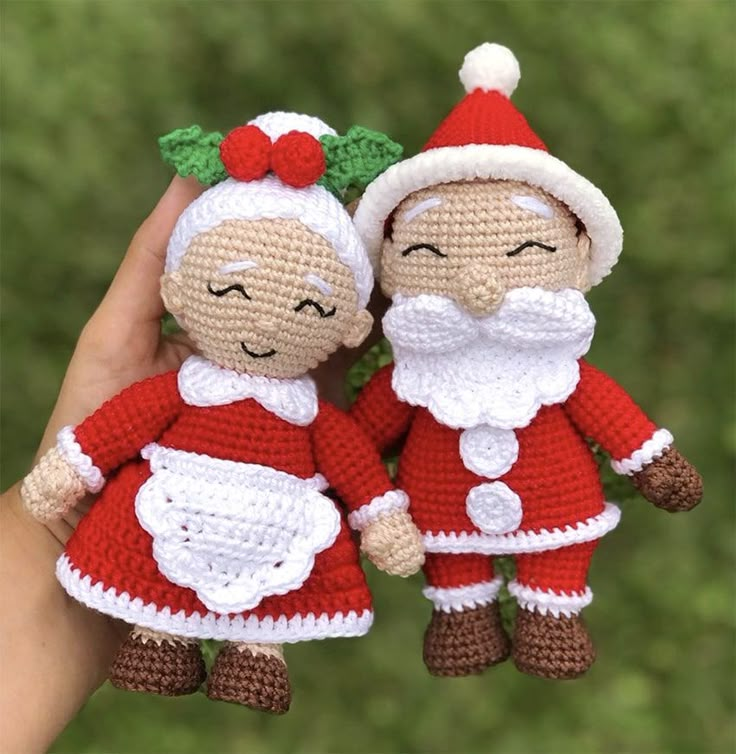 two crocheted santa and mrs claus dolls are held in the palm of someone's hand