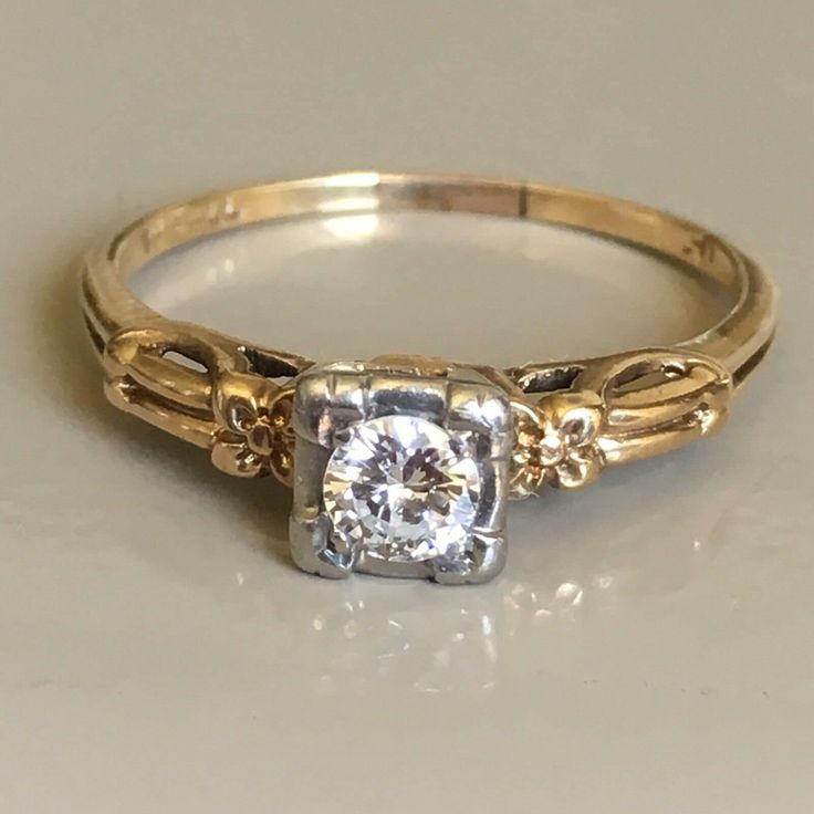 1920s Antique engagement ring Orange Blossom carved work Finger Size 8 Hallmarked 'JF' Jerome Fleischer & Co. Providence, Rhode Island  Karat mark ' 14K-PAll ' Palladium topped 14 Karat Gold  14 Karat yellow gold Palladium topped solitaire ring with Orange Blossom design on sides centering a transition round cut Diamond measuring 4 mm in diameter and by 2.2 mm depth, 1/5 carat in weight, approximately F-G color and VS1 clarity weighting 1.9 gram, finger size 8 Hallmarked 'JF' Jerome Fleischer & Co. Providence, Rhode Island, Purity mark ' 14K-PAll ' Palladium topped 14 Karat Gold in excellent condition considering the age Retro Rings Vintage, Inset Rings Engagement, 40s Engagement Ring, 1980s Engagement Ring, 14k Gold Art Deco Jewelry, Art Deco 14k Gold Promise Ring Jewelry, 14k Gold Art Deco Promise Ring Jewelry, 14k Gold Art Deco Promise Ring, 14k Stamped Platinum Gold Jewelry