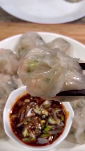 a white plate topped with dumplings covered in sauce