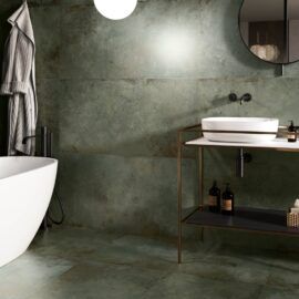 a white bath tub sitting next to a sink in a bathroom under a round mirror