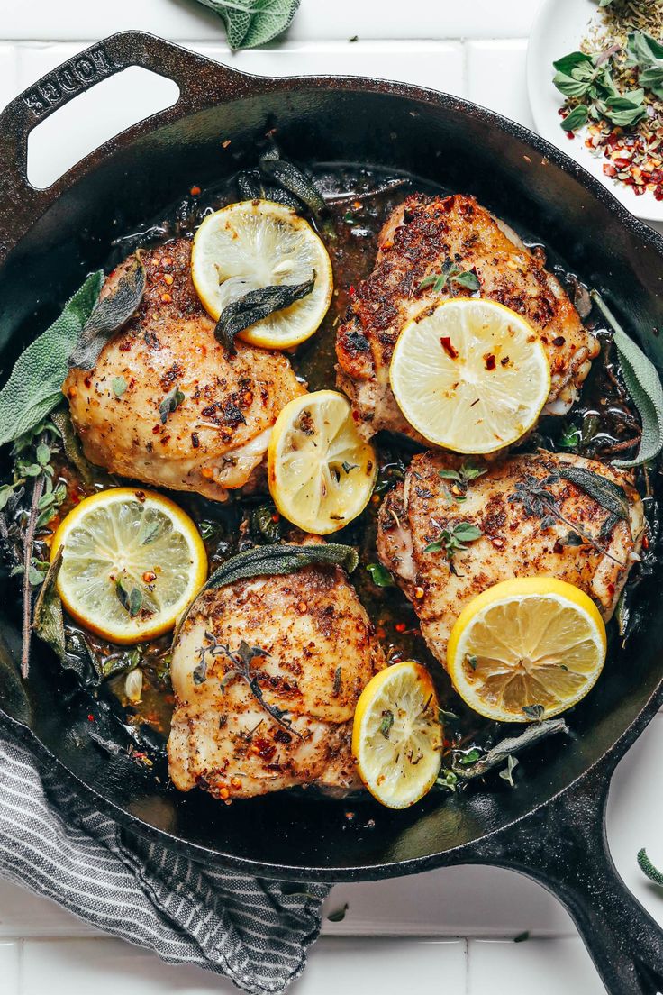 chicken with lemons and herbs in a cast iron skillet