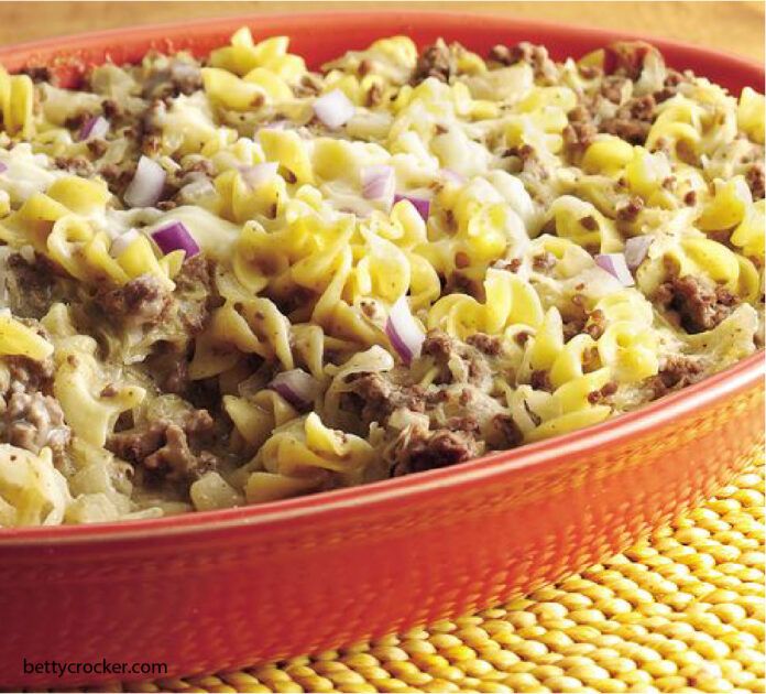 a casserole dish with meat and noodles in it on a yellow place mat