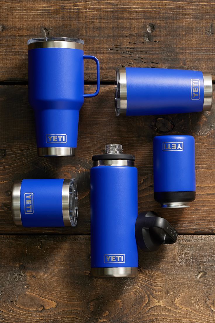 four blue yeti coffee mugs sitting next to each other on a wooden surface