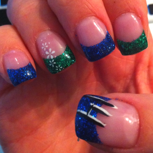 a woman's hand with blue, green and white nails