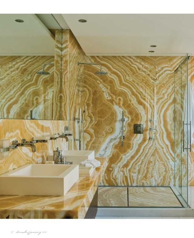 a marble bathroom with two sinks and a walk in shower next to the bathtub