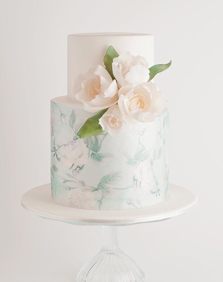 a white and green wedding cake with flowers on the top is featured on instagram