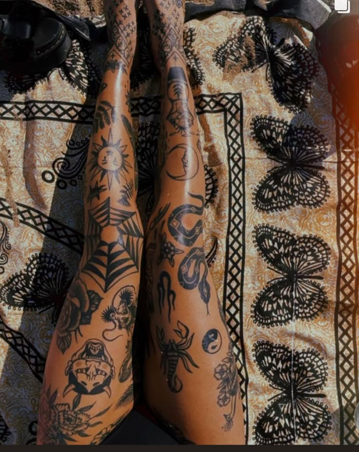 the legs and ankles of a person with tattoos on their body are covered in intricate designs