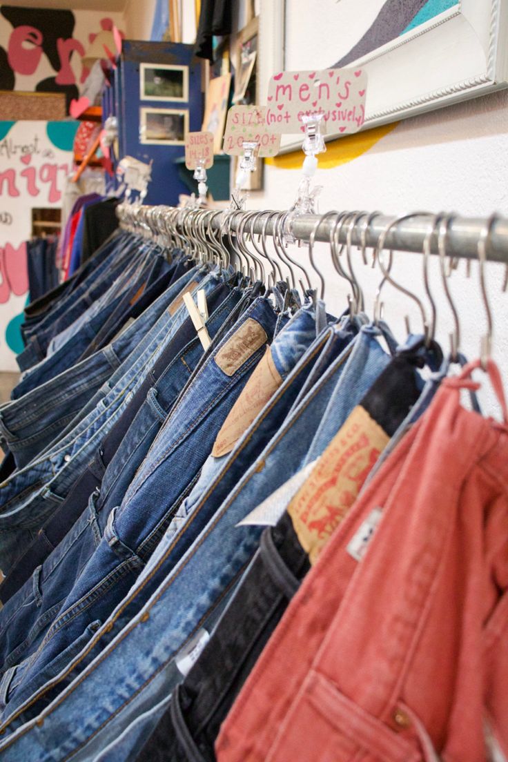 there are many pairs of jeans hanging on the rack