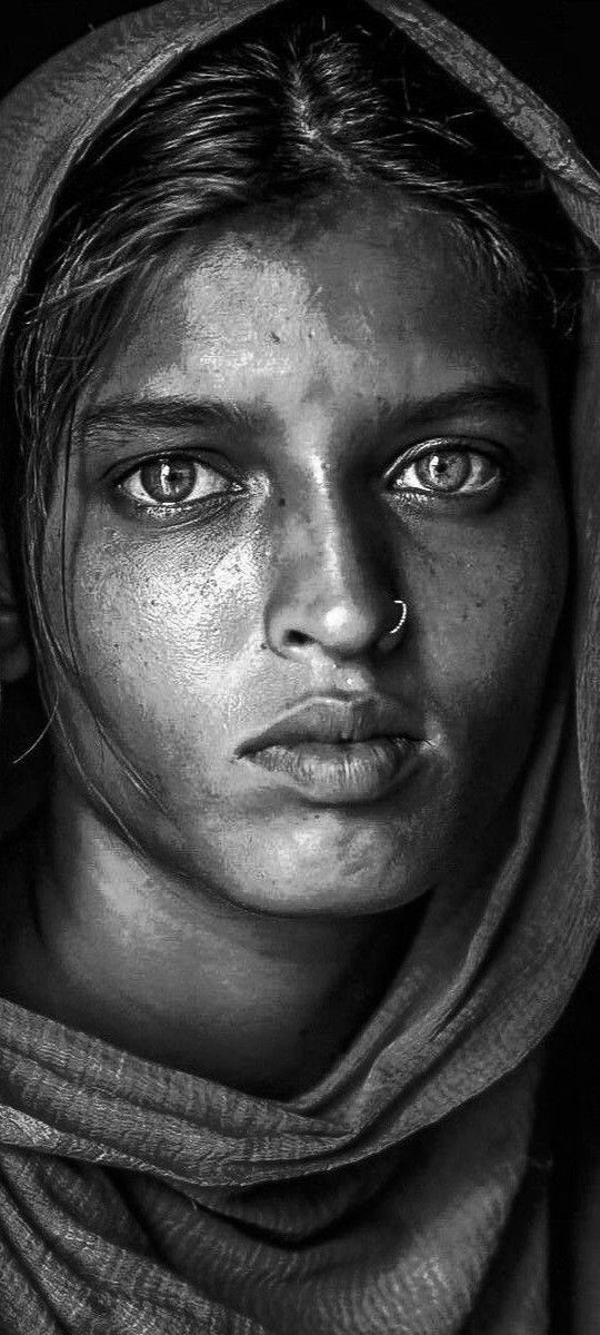 a black and white photo of a woman with freckles on her face looking at the camera