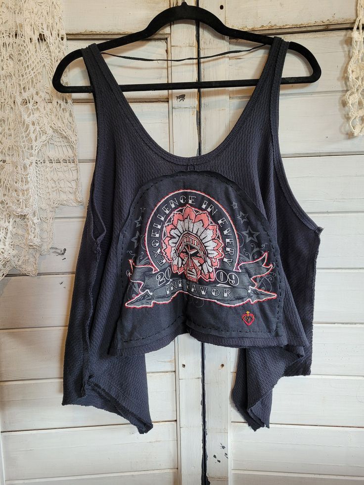 "Free People black tank top, size small.  Uniquely upcycled using vintage t-shirt graphics and fabrics.  All sewing is done by hand including embroidery.  Although marked as a \"small\", typical of Free People brand, this tank top is very roomy.  Chest actually measures 26\" across, neck to hem in center front measures approximately 11\" at shortest point." Cotton Tank Top With Graphic Print For Festivals, Cotton Graphic Print Tank Top For Festivals, Graphic Print Tank Tops For Festivals, Festival Graphic Print Tank Tops, Black Hippie Tops For Music Festival, Distressed Bohemian Top For Festival, Black Hippie Top For Music Festival, Black Bohemian Tank Top, Distressed Cotton Bohemian Tops