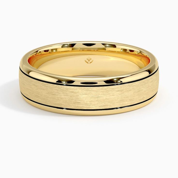 a yellow gold wedding band with black dots on the side and a thin center, set in