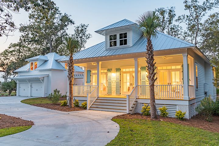 a white house with palm trees in the front yard and walkway leading up to it