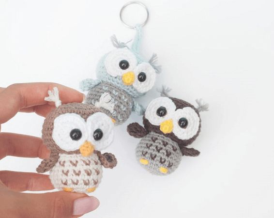 three small crocheted owls sitting next to each other on a person's hand