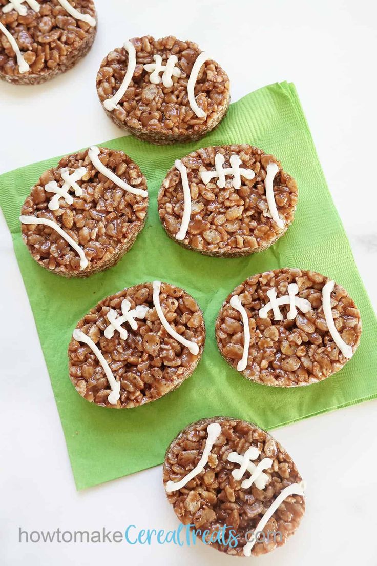 cookies decorated like footballs are sitting on a green napkin