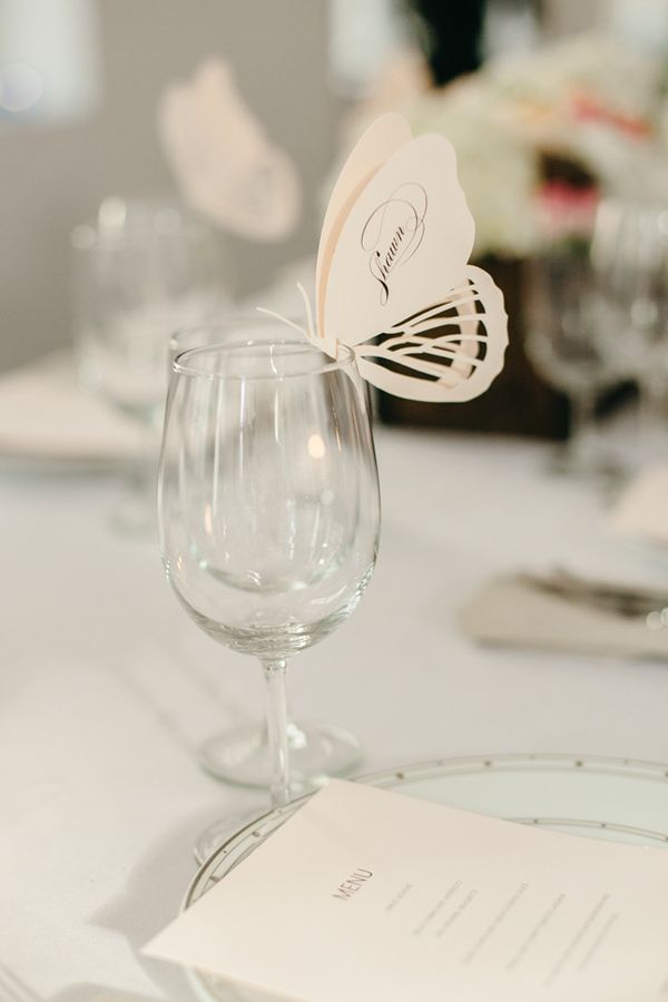 a close up of a wine glass on a table with place settings and napkins