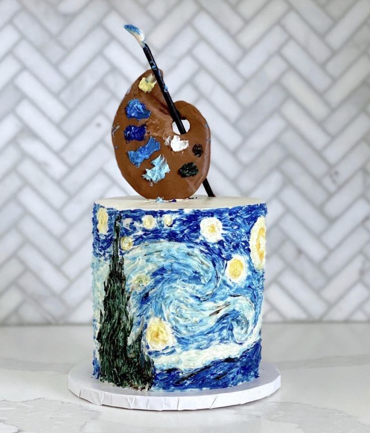 a cake decorated with an image of the starry night and a paintbrush on top