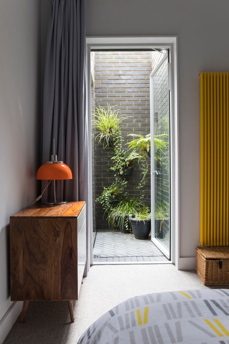 an open door leading to a bedroom with plants