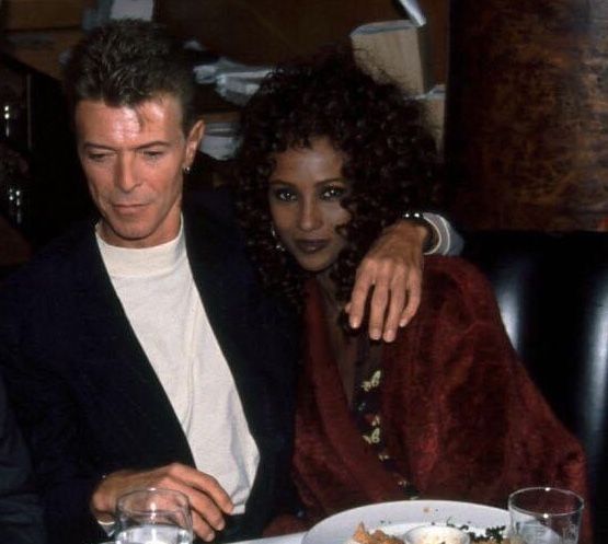 a man and woman sitting at a table with plates of food in front of them