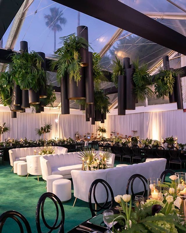 a room filled with tables and chairs covered in plants