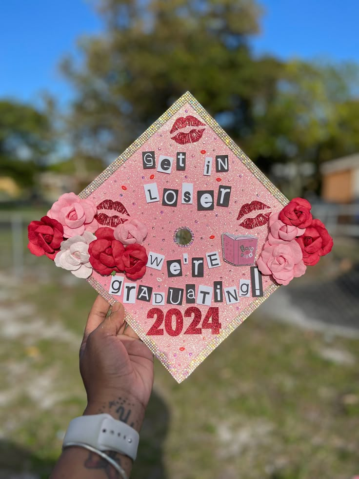 someone is holding up a graduation cap with flowers on it