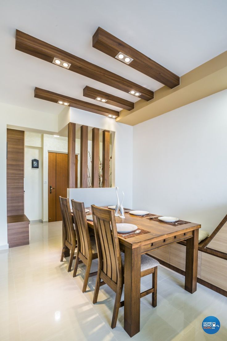 a dining room table and chairs with wooden beams on the ceiling in an open space