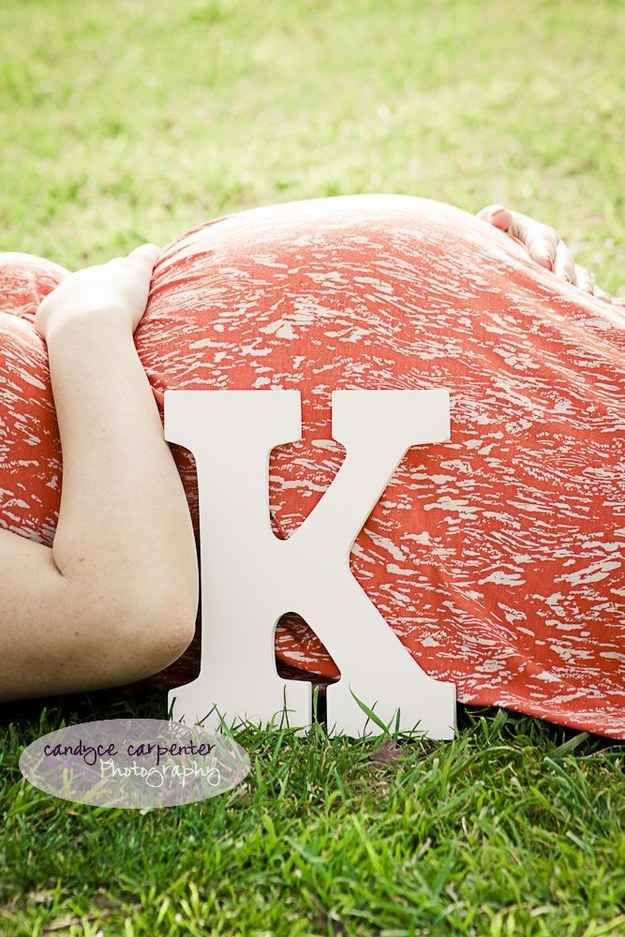 a person laying on top of a pillow with the letter k in front of them