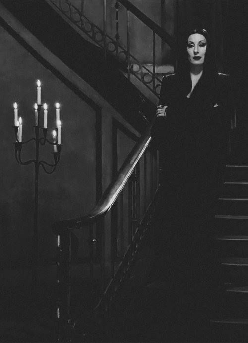 a woman in black is standing on the stairs