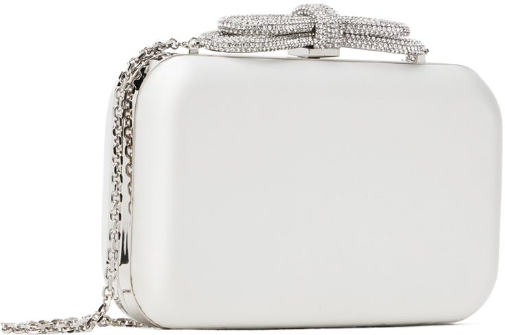 Structured satin clutch in white. · Detachable curb chain shoulder strap · Crystal-cut bow appliqué at clasp · Hinged closure · Grained leather lining · H4.5 x W8 x D2 Supplier color: White Chic Formal Evening Bag With Bow, Elegant Evening Bag With Bow, Luxury White Clutch With Chain Strap, White Luxury Evening Bag, Elegant Wedding Bags With Bow Detail, Elegant Wedding Bags With Bow, Formal White Clutch Evening Bag, Glamorous White Formal Clutch, Elegant White Clutch For Formal Occasions