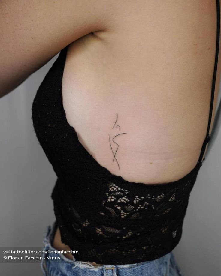 the back of a woman's stomach with a small tattoo on her left side