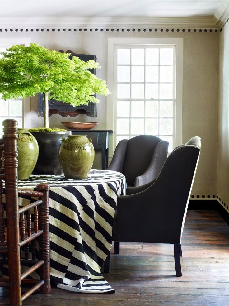 a dining room table with two chairs and a black and white table cloth on it