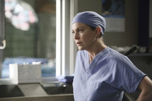 a woman in scrubs standing next to a sink and looking off into the distance