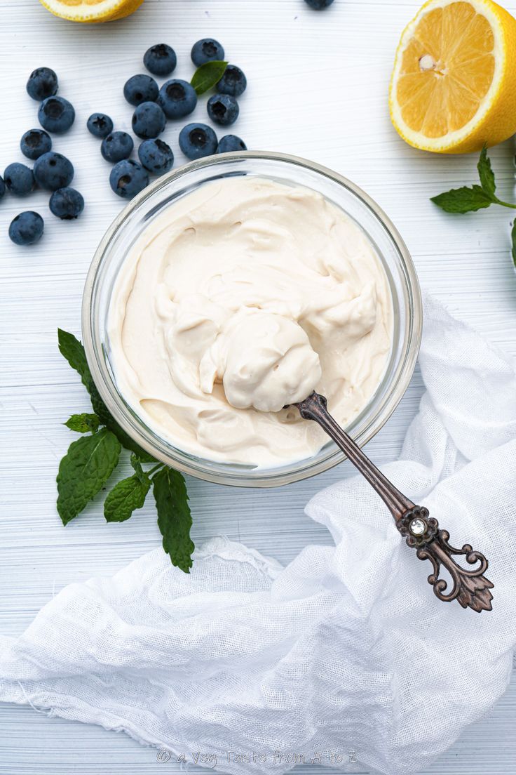 blueberries, lemons and yogurt in a glass bowl on a white table