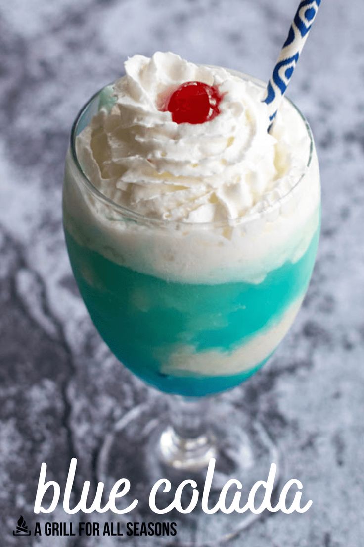 a blue cocktail with whipped cream and a cherry on top