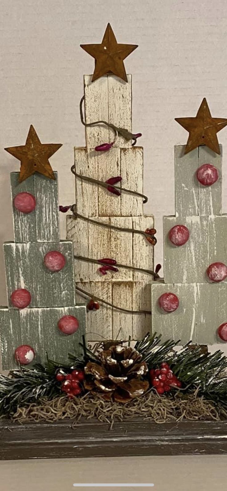 a christmas tree made out of wooden blocks with stars on top and other decorations around it