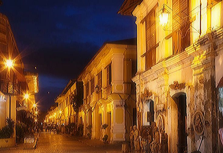 an empty city street at night with lights on