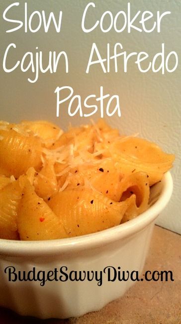 a white bowl filled with pasta on top of a wooden table next to a wall