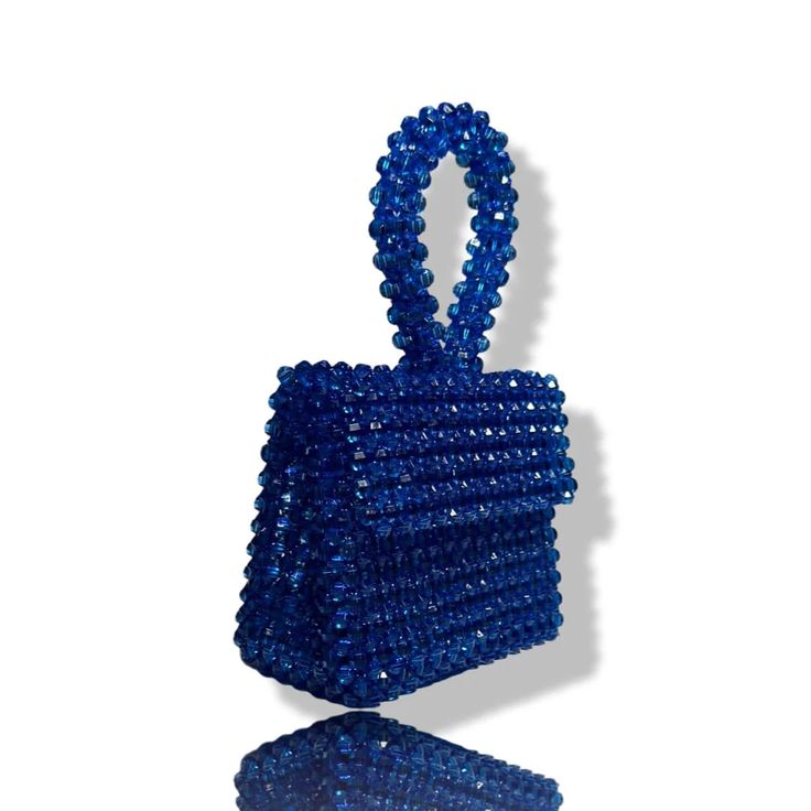 Artisanal Bead Bag.Designed in NYC. Crafted with precision in the heart of Lagos, Nigeria.Introducing our exclusive bead bags – the epitome of timeless elegance and craftsmanship. Chic, streamlined, and adaptable, these handbags are designed to be your enduring companions. Effortlessly blending style and durability, our bead bags transcend trends, seamlessly complementing cocktail dresses, casual denim and tees, professional attire, and becoming the perfect accessory for a night out on the town. Luxury Blue Shoulder Bag For Gift, Luxury Beaded Handheld Evening Bag, Luxury Handheld Beaded Evening Bag, Blue Rectangular Bag With Pearl Handle, Blue Handmade Evening Bag For Everyday Use, Luxury Beaded Top Handle Evening Bag, Elegant Blue Bag With Pearl Handle, Blue Beaded Shoulder Bag As Fashion Accessory, Blue Luxury Clutch With Top Handle