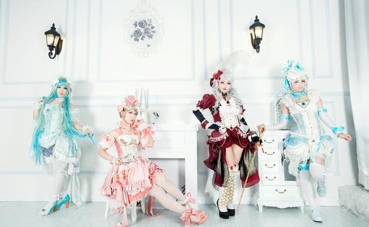 three women dressed in fancy clothes sitting on chairs