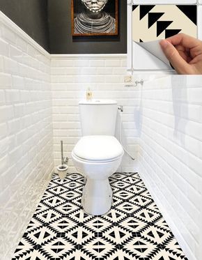 a white toilet sitting in a bathroom next to a black and white tiled flooring