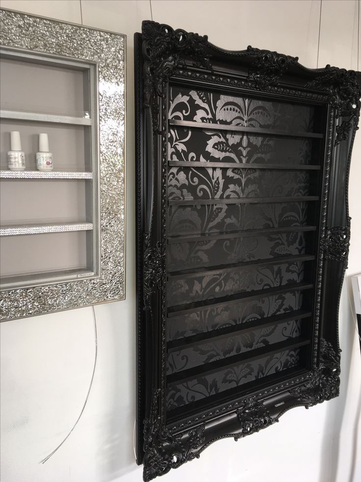 an ornate black framed mirror hanging on the wall