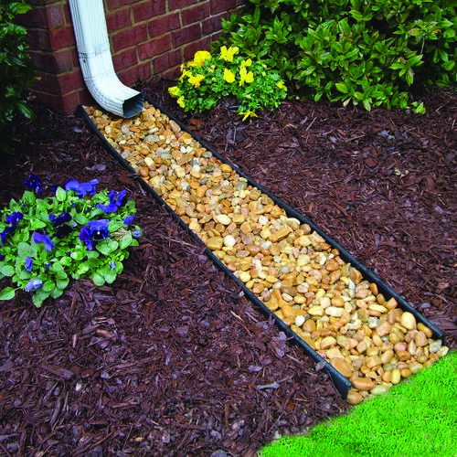 a garden path made out of rocks and mulchs next to a flower bed