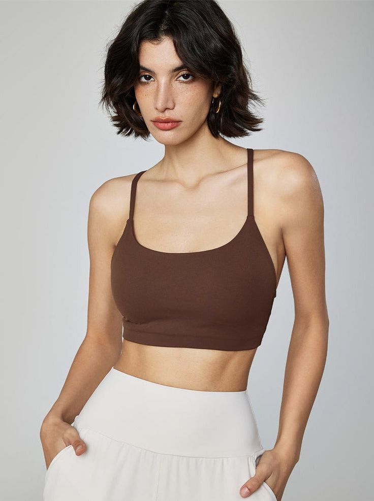 Why We Love It: Achieve peak performance and effortless style with the Gemma Cami Sports Bra. This versatile piece combines a chic design with essential support, perfect for any workout routine. Fit and Features: Light-to-medium support for a wide range of activities. Built-in bra with removable padding for customizable comfort. Scoop neckline adds a touch of elegance. Adjustable straps ensure a perfect fit. Breathable and moisture-wicking fabric keeps you cool and dry. Seamless construction pro Brown Seamless Activewear, Fitted Brown Sports Bra, Brown Fitted Sports Bra For Gym, Fitted Brown Sports Bra For Gym, Sporty Brown Activewear For Training, Brown Athleisure Activewear For Training, Sporty Brown Sports Bra For Gym, Brown Fitted Sporty Activewear, Brown Workout Activewear