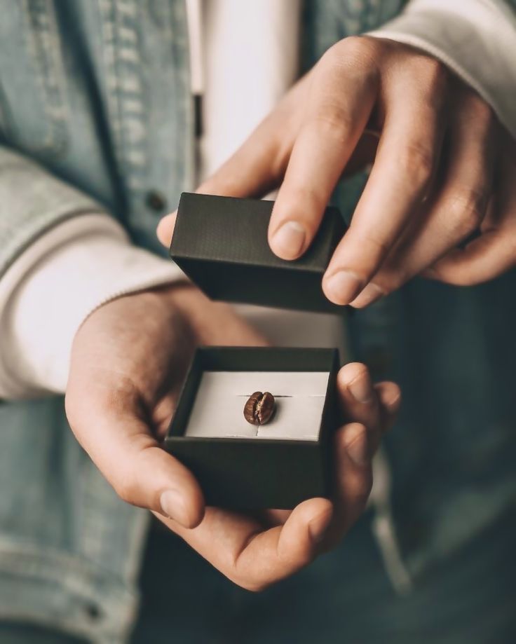 a man is holding an engagement ring in his hand and it's inside the box