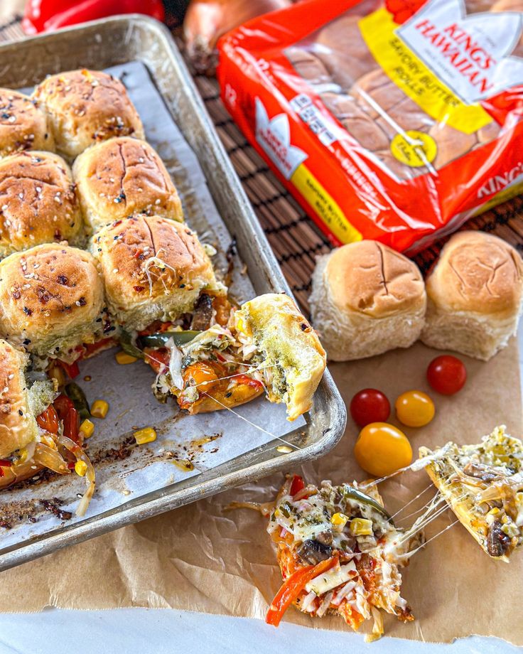 a pan filled with sliders and other food items