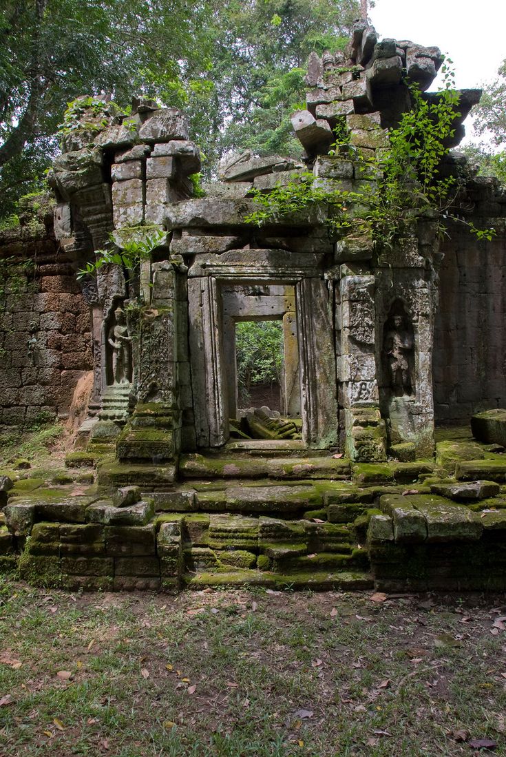 an old building with moss growing on it's walls and steps leading up to the entrance