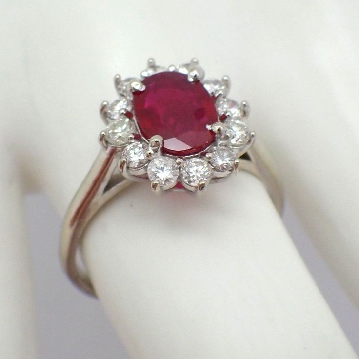 Vintage 14k (.585) white gold ring, having oval-cut Natural Ruby centerpiece accompanied by Diamond halo.  This majestic ring is a size 8, it is 14 mm at the widest, weighing 3.8 grams. The Ruby measures 8.62 mm x 6.4 mm x 2.15 mm, approx. 0.85ct. 12 Diamonds are approx. 0.4ctw, SI clarity, color G-H. EA3969 Formal Oval Ruby Ring In Platinum, Oval Ruby Ring In Platinum For Formal Occasions, Gia Certified Oval Platinum Cluster Ring, Gia Certified Oval Cluster Ring, Gia Certified Oval Ruby Ring In Silver, Gia Certified Silver Oval Ruby Ring, Gia Certified Oval Ruby Ring With Silver Setting, Oval Halo Ring Gia Certified For Anniversary, Gia Certified Oval Ruby Ring For Wedding