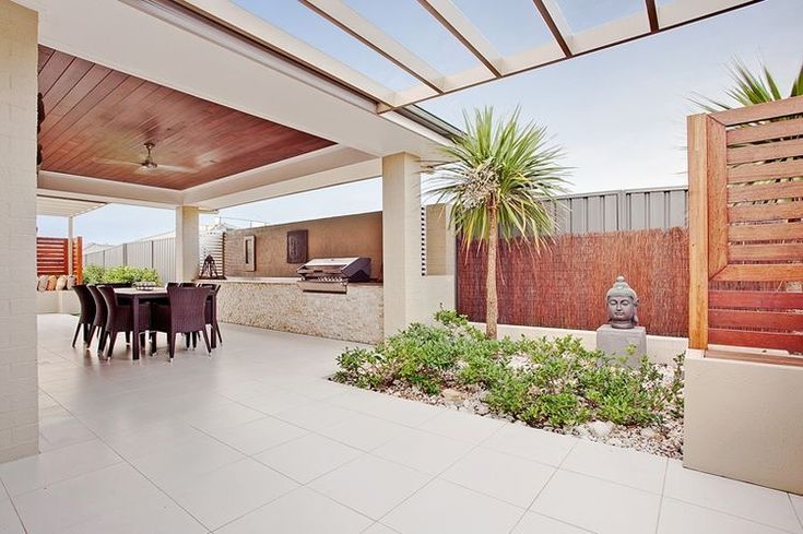 an outdoor kitchen and dining area is shown in this photo, with white tiles on the floor