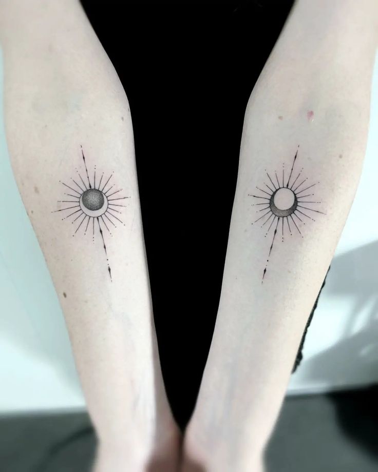 two sun and moon tattoos on both arms, one is black with white dots in the middle