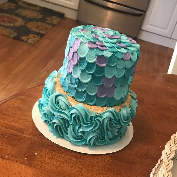 a blue and purple cake sitting on top of a wooden table